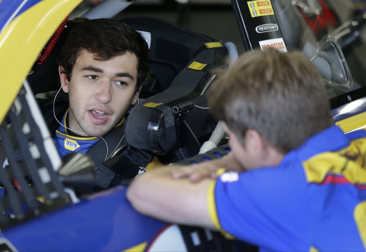 Chase Elliott talks to a crew member at Charlotte Motor Speedway. (AP Photo/Chuck Burton)