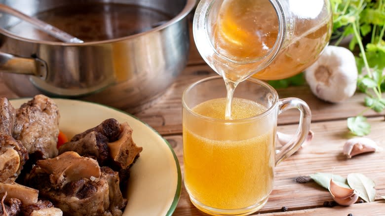 Cup of broth pouring