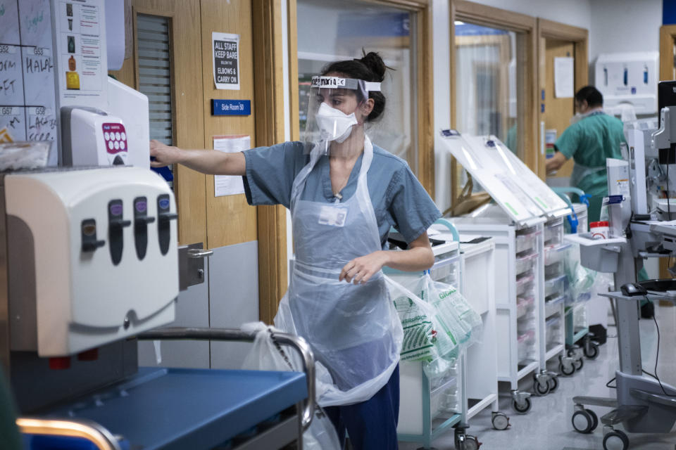 A staff nurse puts on PPE in the corridor of the Acute Dependency Unit at St George's Hospital in Tooting, south-west London.