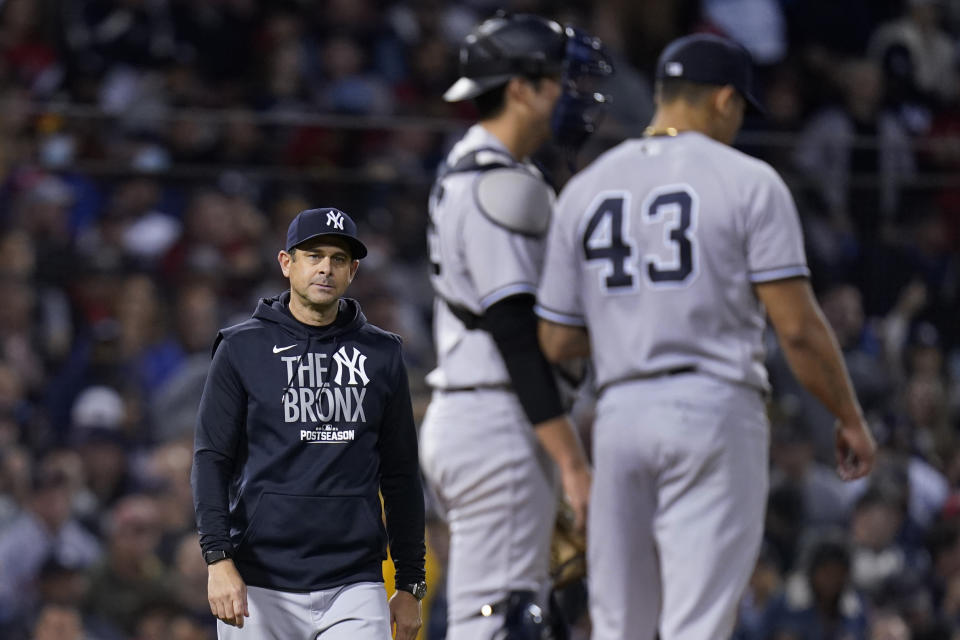 New York Yankees manager Aaron Boone, left, walks to the mound to remove relief pitcher Jonathan Loaisiga (43) in the seventh inning of an American League Wild Card playoff baseball game at Fenway Park against the Boston Red Sox, Tuesday, Oct. 5, 2021, in Boston. (AP Photo/Charles Krupa)