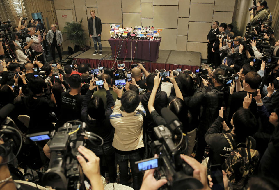 Hong Kong singer Andy Hui stands and let photographers take pictures before a press conference about his affair in Hong Kong, Tuesday, April 16, 2019. Hong Kong's Apple Daily newspaper published video that purported to show Andy Hui being intimate in a taxi with another Hong actress, decades younger than him, Jacqueline Wong. (AP Photo/Vincent Yu)