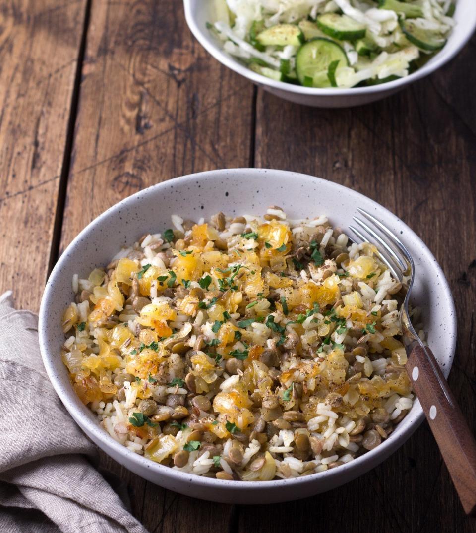 A bowl of mejadra made with rice, lentils, and onion.