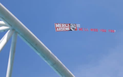 An airplane flies over the stadium with a message to Arsene Wenger - Credit: Getty