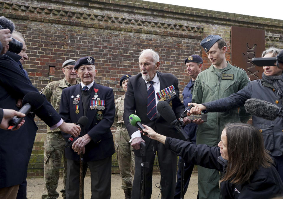 D-Day veterans Stan Ford, left, and John Roberts after receiving their memorial plaques in front of the Normandy Memorial Wall in Portsmouth, England, Tuesday Feb. 27, 2024. With medals pinned to their chests, the two D-Day veterans proudly represented their comrades as 13 new names were added to the memorial wall in southern England that honors those who took part in the Normandy landings. (Gareth Fuller/PA via AP)