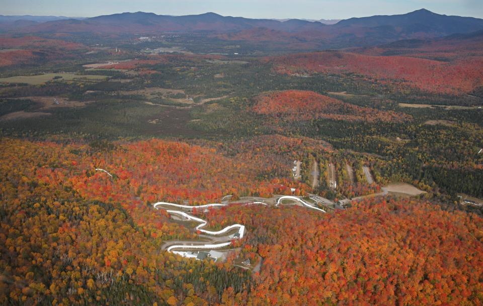 The twists and turns of the Mount Van Hoevenberg Olympic Bobsled Run are surrounded by the exploding colors of fall deep in the Adirondacks near Lake Placid.  The photo was taken on a foliage flight over the High Peaks by Adirondack Flying Services in Lake Placid.  