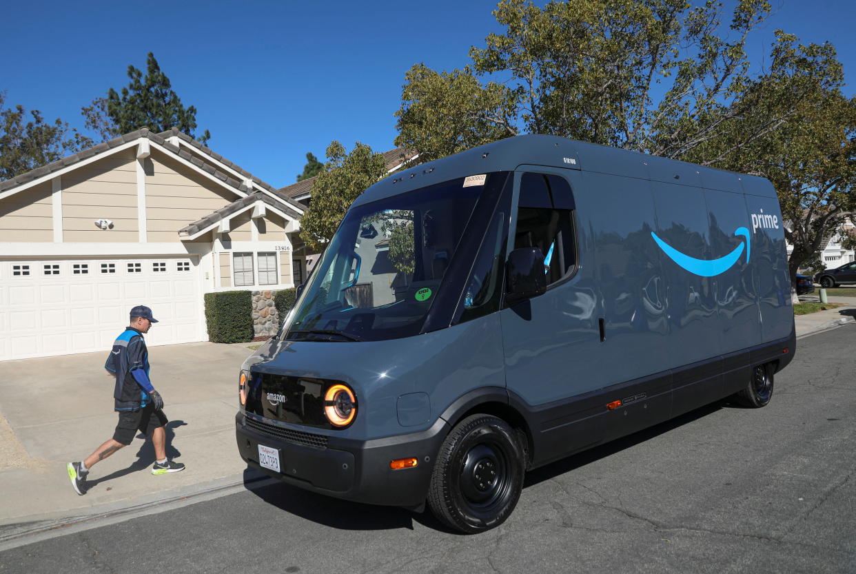 Driver David Gonzalez walks back to his truck after delivery in an Amazon Rivian Electric truck in Poway, California, U.S., November 16, 2022. REUTERS/Sandy Huffaker