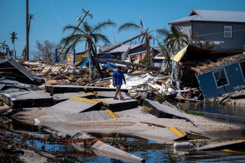 <div class="inline-image__caption"><p>A man walks over a broken section of the Pine Island Road in the aftermath of Hurricane Ian.</p></div> <div class="inline-image__credit">Ricardo Arduengo/Getty</div>