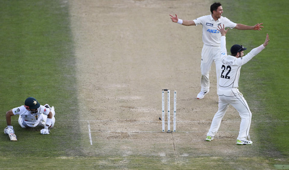 Pakistan captain Mohammad Rizwan, left, is run out after a direct throw by Mitchell Santner, not pictured, as Trent Boult and Kane Williamson, right, appeal during play on day three of the first cricket test between Pakistan and New Zealand at Bay Oval, Mount Maunganui, New Zealand, Monday, Dec. 28, 2020. (Andrew Cornaga/Photosport via AP)