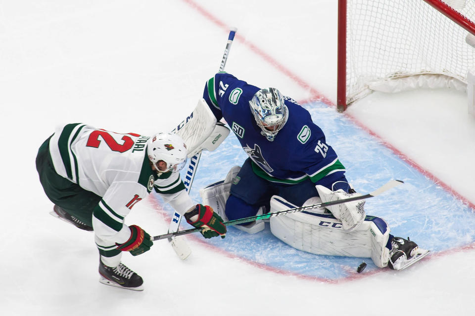 Vancouver Canucks goaltender Jacob Markstrom (25) makes a save against Minnesota Wild's Eric Staal (12) during the third period of an NHL hockey playoff game Sunday, Aug. 2, 2020, in Edmonton, Alberta. (Codie McLachlan/The Canadian Press via AP)