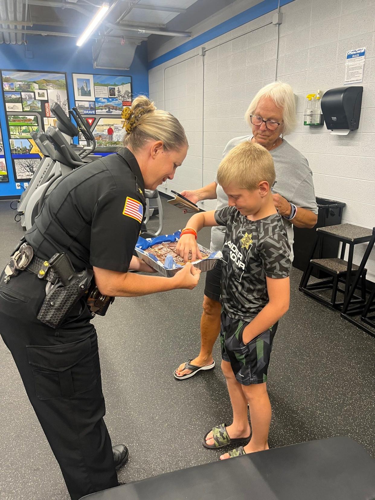 Baker Lois Hartwig and her grandson Waylen share Heavenly Bars with Ozaukee County Sheriff Christy Knowles.