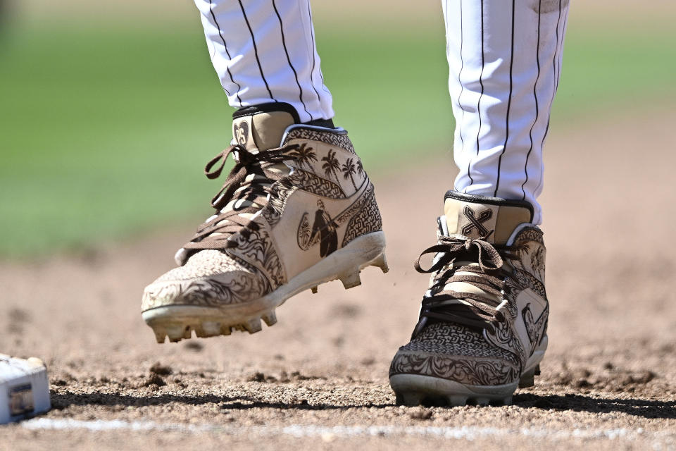 FILE - San Diego Padres' outfielder Fernando Tatis Jr. (23) wears cleats in memory of former San Diego Padres owner Peter Seidler during an Opening Day baseball game between the San Francisco Giants and the San Diego Padres, Thursday, March 28, 2024, in San Diego. Tatis plans to unveil 50 pairs of custom cleats this season in conjunction with his branding company, Xample, and Los Angeles-based Shoe Surgeon. The cleats will honor people, events and whatever strikes the 25-year-old Tatis' fancy. (AP Photo/Denis Poroy, File)