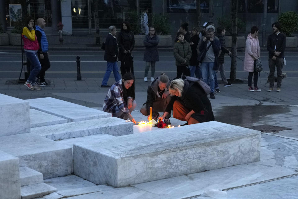 People light candles for the victims near the Vladislav Ribnikar school in Belgrade, Serbia, Wednesday, May 3, 2023. Police say a 13-year-old who opened fire at his school drew sketches of classrooms and made a list of people he intended to target. He killed eight fellow students and a school guard before being arrested. (AP Photo/Darko Vojinovic)