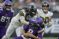 New Orleans Saints linebacker Demario Davis (56) sacks Minnesota Vikings quarterback Kirk Cousins (8) during an NFL match between Minnesota Vikings and New Orleans Saints at the Tottenham Hotspur stadium in London, Sunday, Oct. 2, 2022. (AP Photo/Frank Augstein)