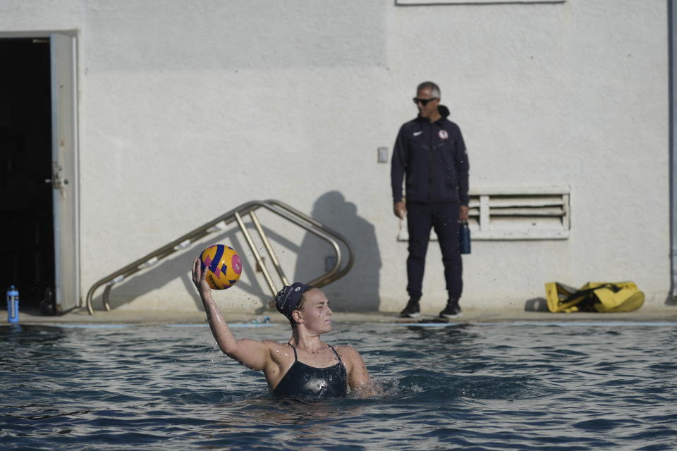 U.S. Women's Water Polo player Ella Woodhead practices at MWR Aquatic Training Center in Los Alamitos, Calif., Thursday, Jan. 18, 2024. At right is Adam Krikorian, Women's Senior National Team head coach. The U.S. water polo teams for the Olympics could have a much deeper connection than just a mutual love of their grueling sport. Chase and Ryder Dodd are trying to make the men's roster, alongside another pair of brothers in Dylan and Quinn Woodhead. Ella Woodhead, Dylan and Quinn's sister, is in the mix for the loaded women's squad. The Woodheads are from Northern California, and the Dodds grew up in Southern California. There are a couple more siblings in different sports who also could be competing in Paris this summer. (AP Photo/Damian Dovarganes)