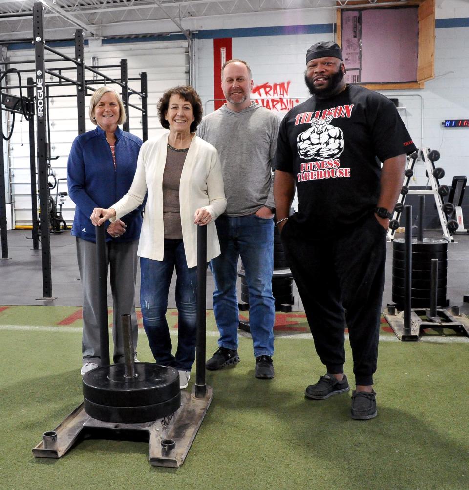 Linda Thompson shows the sled she had just finished pushing when she collapsed at Tillison Fitness Warehouse in Orrville. Melinda Budd, Ryan McAllister and Thad Tillison took quick action to save her life, including using an AED device the gym had previously purchased.