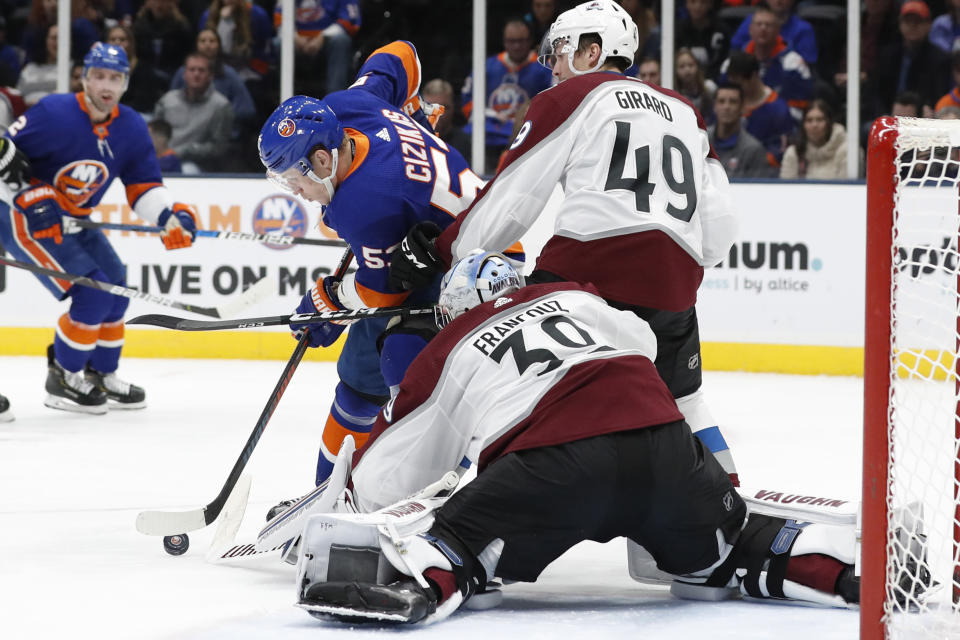 Colorado Avalanche defenseman Samuel Girard (49) defends New York Islanders center Casey Cizikas (53) who tries to maneuver the puck in front of Avalanche goaltender Pavel Francouz (39) during the second period of an NHL hockey game, Monday, Jan. 6, 2020, in Uniondale, N.Y. (AP Photo/Kathy Willens)