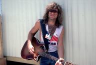 <p>Bon Jovi rocks his signature feathery 'do and a muscle tee while performing at the Farm Aid Concert in Austin, Texas in 1986. That same year, the singer put out his third album, <em>Slippery When Wet</em>. </p>