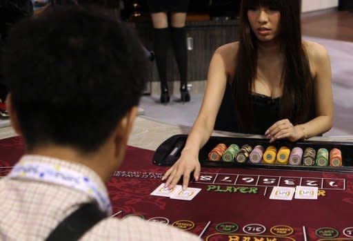 A hostess deals cards during a baccarat demonstration at the G2E Asia gaming expo in Macau on May 23. As billions of dollars pour into Asia's gleaming casinos, they are becoming the front line of a sometimes hugely lucrative battle between cheats and the house, say experts