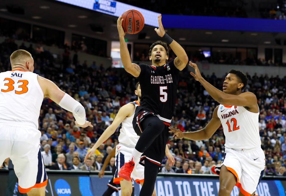 COLUMBIA, SOUTH CAROLINA - MARCH 22: Jose Perez #5 of the Gardner Webb Runnin Bulldogs drives to the basket against Jack Salt #33 and De'Andre Hunter #12 of the Virginia Cavaliers in the first half during the first round of the 2019 NCAA Men's Basketball Tournament at Colonial Life Arena on March 22, 2019 in Columbia, South Carolina. (Photo by Kevin C.  Cox/Getty Images)