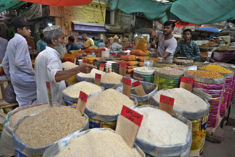 People buy rice and other items at a market, in Karachi, Pakistan, Thursday, July 13, 2023. Pakistan’s finance minister on Thursday said the International Monetary Fund deposited a much-awaited first installment of $1.2 billion with the country’s central bank under a recently signed bailout aimed at enabling the impoverished Islamic nation to avoid defaulting on its debt repayments. (AP Photo/Fareed Khan)