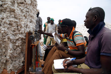 Farmers weigh cotton at a cotton market in Soungalodaga village near Bobo-Dioulasso, Burkina Faso March 8, 2017. REUTERS/Luc Gnago