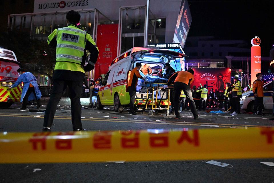 Medical staff attend to a person on a stretcher in the popular nightlife district of Itaewon in Seoul on October 30, 2022.