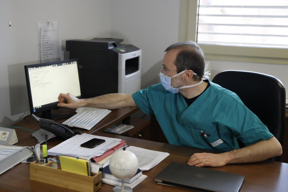 In this March 16, 2020, photo, Sergio Cattaneo, head of anesthesiology and intensive care at Brescia Ospedali Civili hospital, talks with The Associated Press about the coronavirus, in Brescia, Italy. "What is really shocking — something we had not been able to forecast and brought us to our knees — is the quickness the epidemic spreads,” Cattaneo said. "If the spreading of this epidemic is not put under control, it will bring all hospitals to their knees." (AP Photo/Luca Bruno)