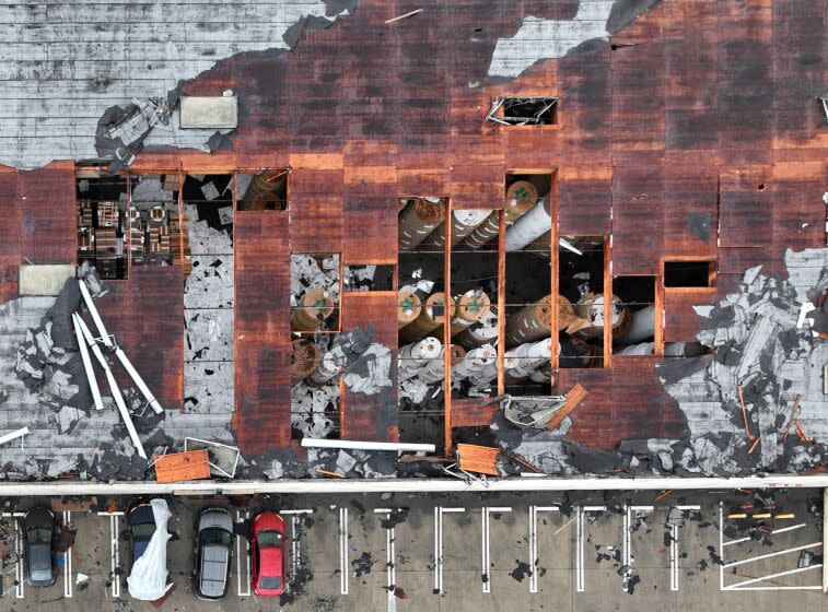 Montebello, CA - March 22: Crews start to clean up debris after a strong microburst -- which some witnesses dubbed a possible tornado -- which injured one person and heavily damaged several cars and buildings, including the roof of the Royal Paper Box Company, shown in photo, in Montebello Wednesday, March 22, 2023. Five buildings have been damaged and one has been red-tagged. Video from the scene showing portions of rooftops being ripped off industrial structures and debris swirling in the air. The National Weather Service on Tuesday night issued a brief tornado warning in southwestern Los Angeles County, but it was allowed to expire after about 15 minutes when weather conditions eased. There was no such warning in place late Wednesday morning when the powerful winds hit Montebello, near the area of Washington Boulevard and Vail Avenue. (Allen J. Schaben / Los Angeles Times)