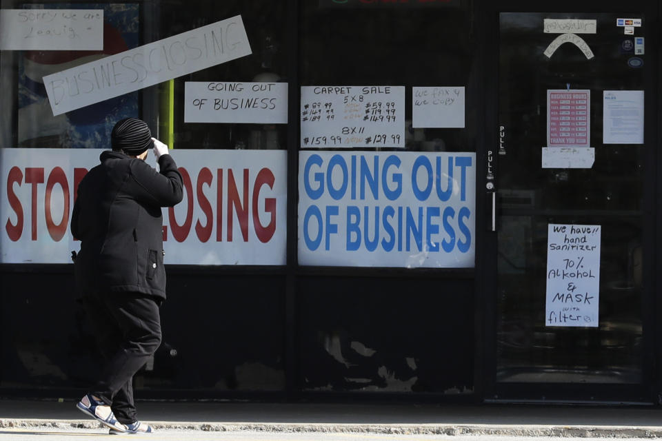 A woman looks at signs at a store in Niles, Ill., Wednesday, May 13, 2020. COVID-19 has spread to most countries around the world, claiming over 270,000 lives with over 3.9 million infections reported. The Bureau of Labor Statistics reported that the U.S. economy lost 20.5 million jobs in April. (AP Photo/Nam Y. Huh)