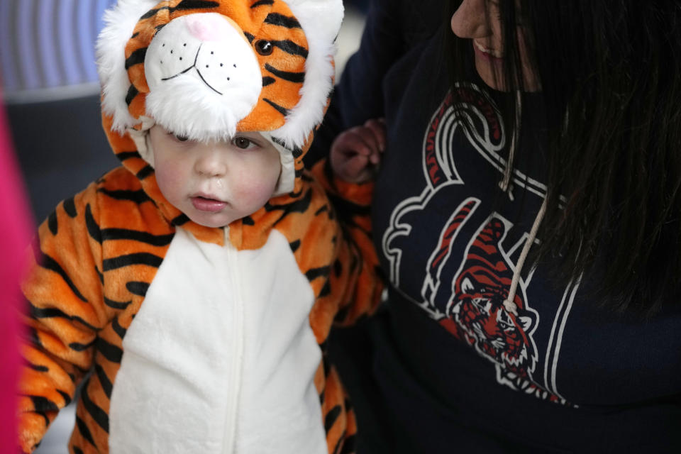 Lucas Cogley, 2, is seen with his mother before the Detroit Tigers' home baseball opener against the Oakland Athletics, Friday, April 5, 2024, in Detroit. (AP Photo/Carlos Osorio)