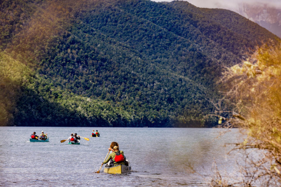 Boats paddling across a lake on Race to Survive: New Zealand