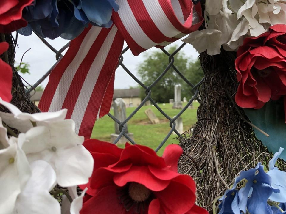A patriotic wreath adorns the fence of the Seceder Cemetery in Reynoldsburg. Twelve veterans from four early wars are buried there.