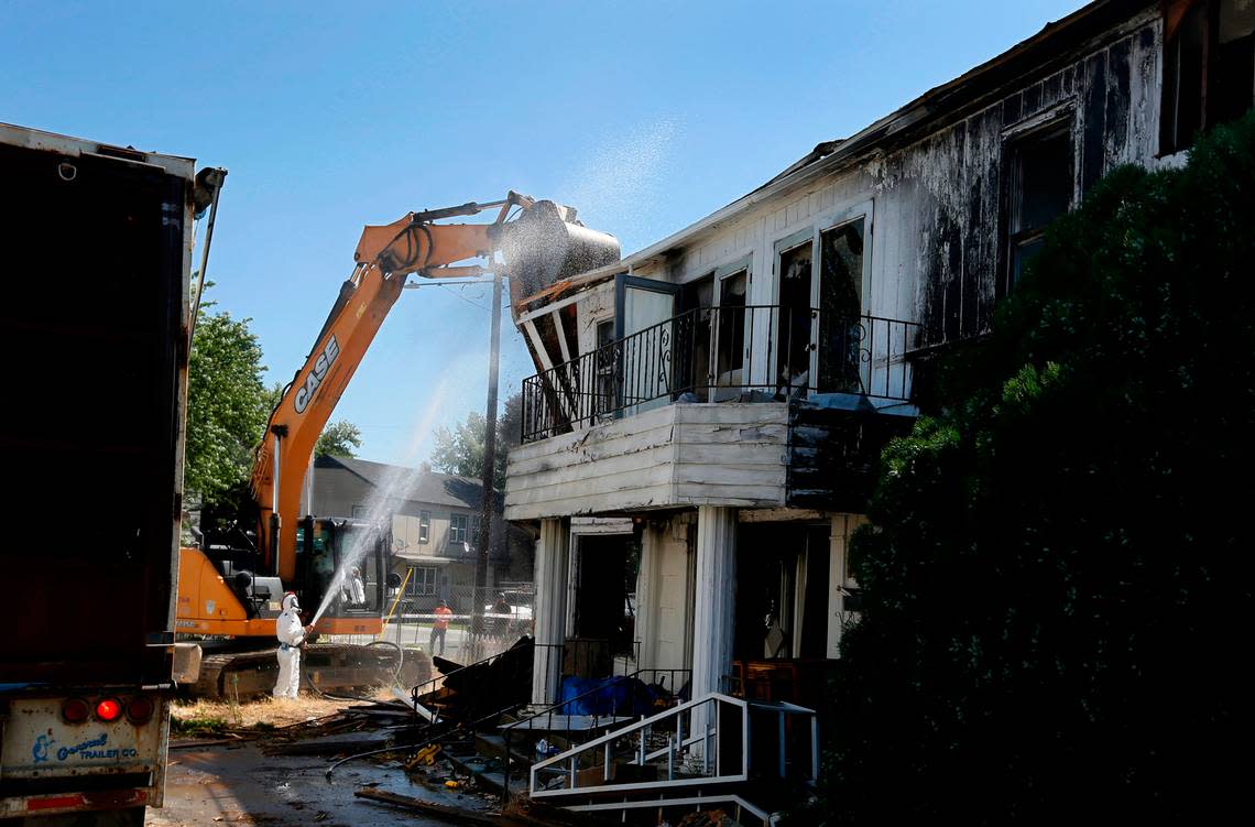 Workers from Big D’s Construction use respirators and wear protective coveralls as they start razing the house damaged by fire three years ago. Bob Brawdy/bbrawdy@tricityherald.com