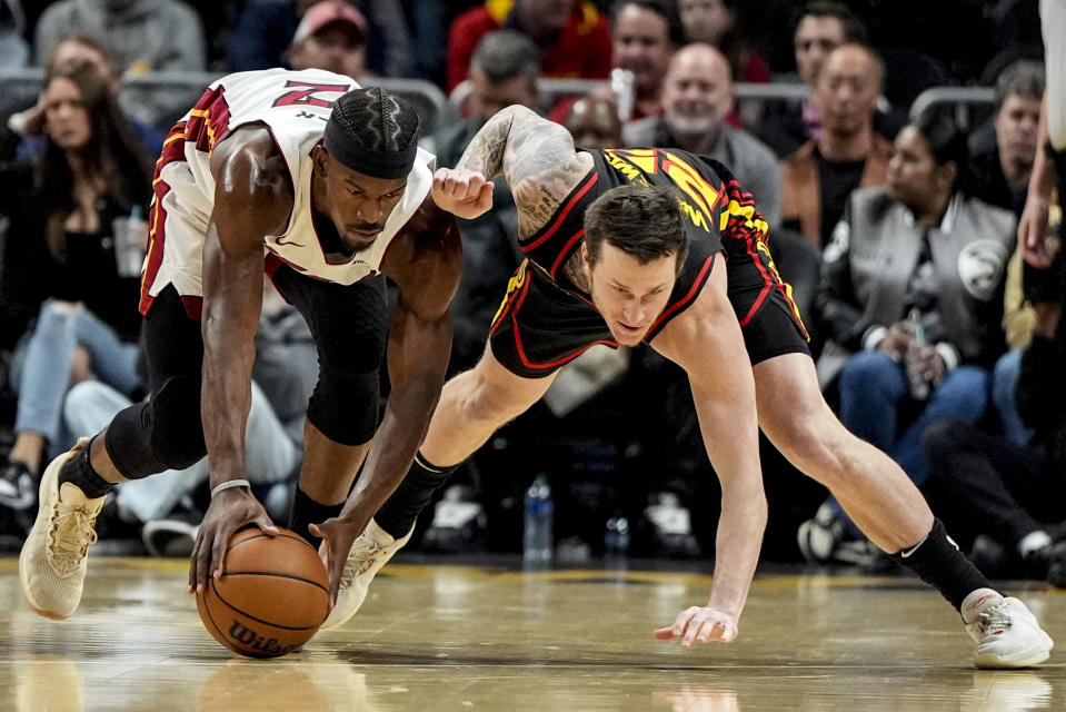 Atlanta Hawks guard Garrison Mathews (25) and Miami Heat forward Jimmy Butler (22) chase a loose ball during the first half of an NBA basketball game, Tuesday, April 9, 2024, in Atlanta. (AP Photo/Mike Stewart)