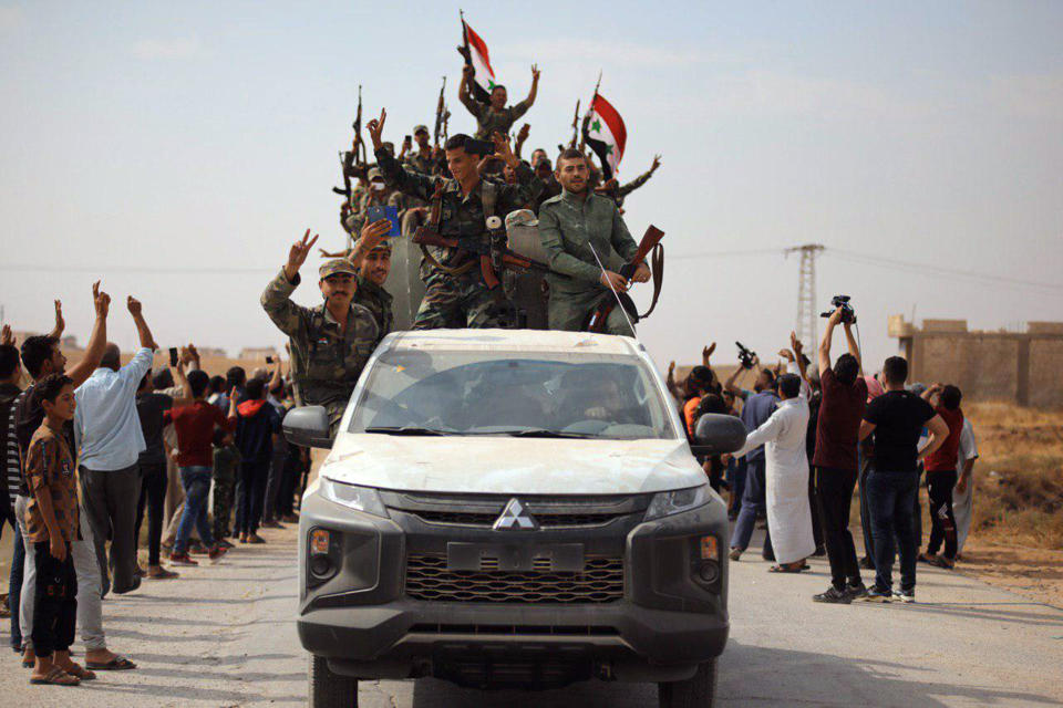 FILE - In this photo released by the Syrian official news agency SANA, people welcome Syrian troops as they enter the town of Ein Issa, north of Raqqa, Syria, on Oct 14, 2019. Syria’s civil war has entered its 14th year on Friday March 15, 2024, a somber anniversary in a long-frozen conflict. The country is effectively carved up into areas controlled by the Damascus government, various opposition groups and Kurdish forces. (SANA via AP, File)