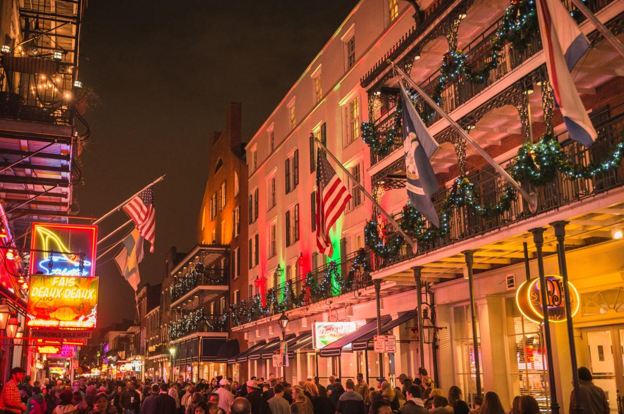 Christmas season in the French Quarter at night, New Orleans, lots of people along the street and buildings with holiday decorations