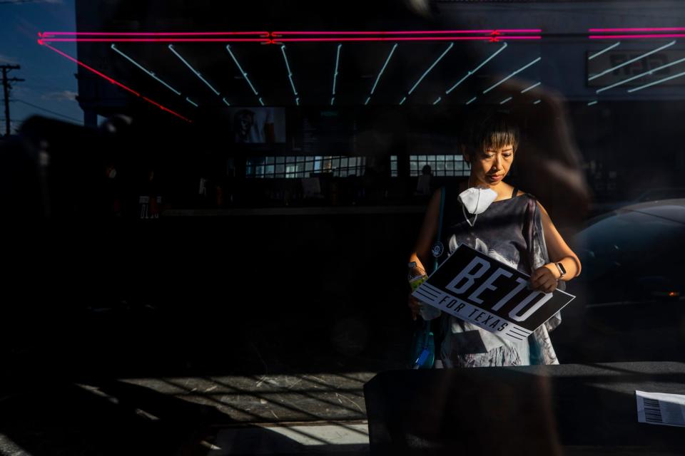 A Beto O'Rourke supporter picks up her campaign sign during the "Drive for Texas" campaign kickoff rally at the Lowbrow Palace in El Paso on July 19, 2022.