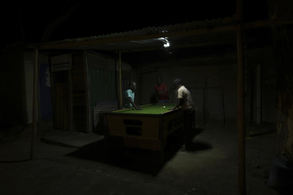 People play pool in an open space in Harare, Zimbabwe, Wednesday, Nov. 30, 2022. Previously a minority and elite sport in Zimbabwe, the game has increased in popularity over the years, first as a pastime and now as a survival mode for many in a country where employment is hard to come by. (AP Photo/Tsvangirayi Mukwazhi)