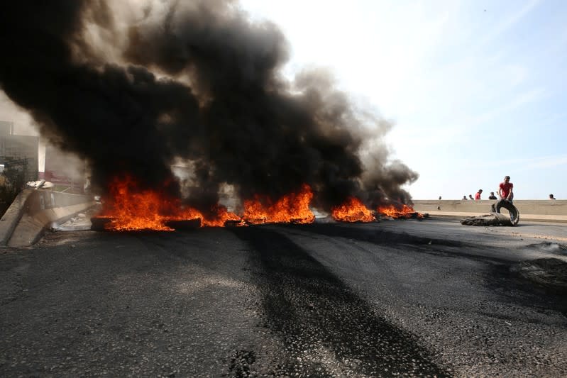 Burning tires block off a main road leading from southern Lebanon to Beirut during a protest targeting the government over an economic crisis, at Barja