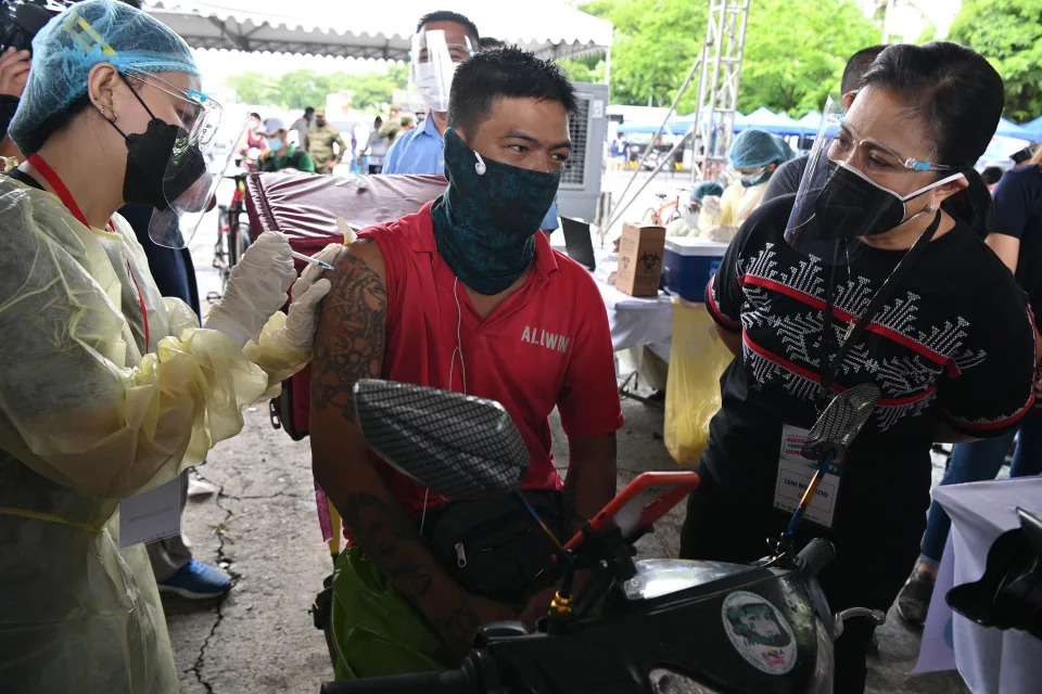 Philippine Vice-President Leni Robredo (R) watches as a volunteer medical worker (L) administers a dose of the Sinovac COVID-19 vaccine to a delivery worker during a vaccination drive for economic frontliners, organized by the vice president&#39;s office and city government, in Manila on July 20, 2021. (Photo by Ted ALJIBE / AFP) (Photo by TED ALJIBE/AFP via Getty Images)