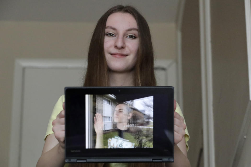 In this April 28, 2020 photo, Zofia Oles holds her photo (Glass Bubble) in her laptop in Willowbrook, Ill. Oles is a senior at Hinsdale South high school and submitted her art work to the the Illinois State Museum, which is documenting what daily life is like for Illinois families during the coronavirus pandemic. (AP Photo/Nam Y. Huh)