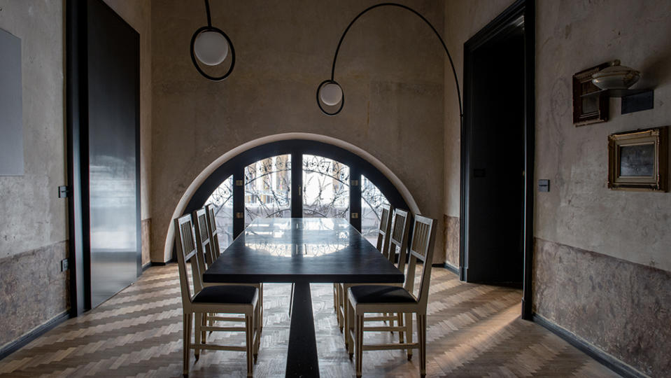 In the dining room, chairs from the San Carlo Theater surround a black marble table by Angelo Mangiarotti