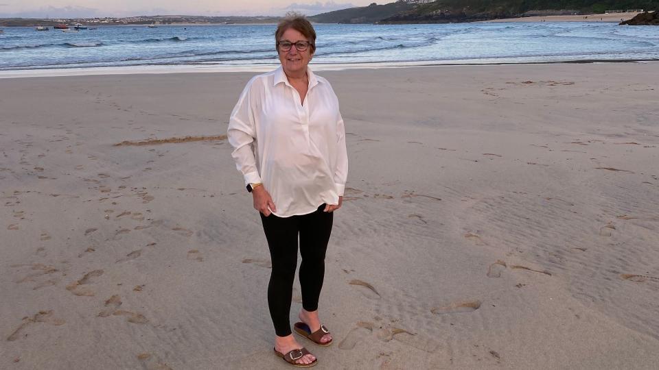 woman standing on the beach in a white shirt