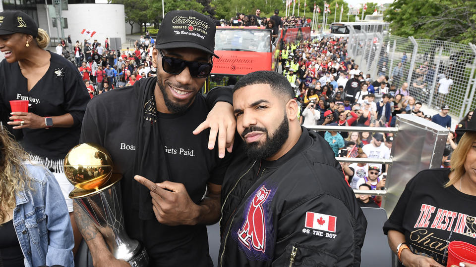 Toronto Raptors forward Kawhi Leonard points at his playoffs MVP trophy as he poses with performing artist Drake during the 2019 Toronto Raptors Championship parade in Toronto on Monday, June 17, 2019. THE CANADIAN PRESS/Frank Gunn