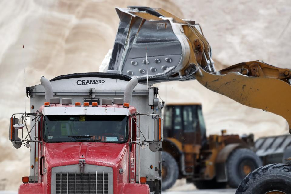 A front-end loader dumps road salt into a truck Friday, Jan. 28, 2022, in Chelsea, Mass. Residents and officials in the Northeast and mid-Atlantic regions of the U.S. are bracing for a powerful winter storm expected to produce blizzard conditions Friday and Saturday. (AP Photo/Michael Dwyer)