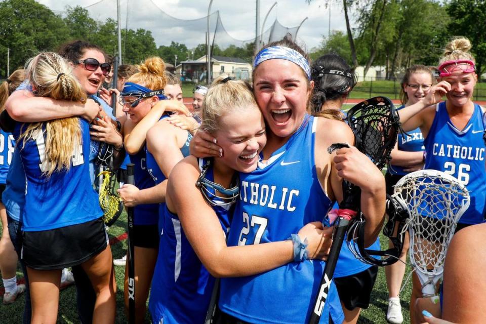 Lily Hester, left, celebrates with Emma Potter (27) after scoring the winning goal for Lexington Catholic in the second sudden-death overtime Saturday in the Commonwealth Lacrosse League girls’ championship game.