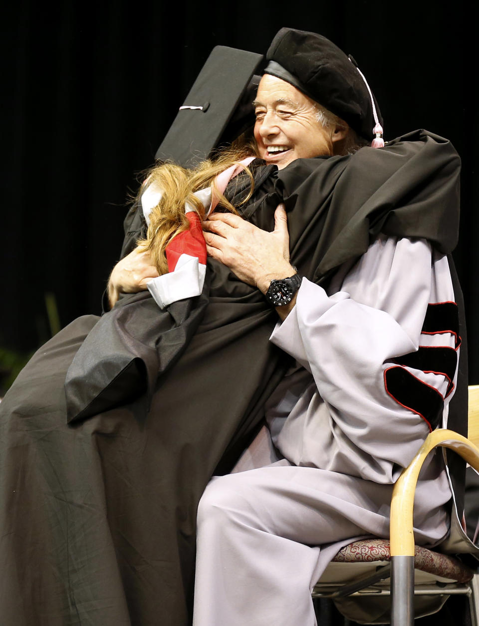 Just before receiving her degree, Berklee College of Music graduate Eden Forman of Gloucester, Mass. hugs former Led Zeppelin guitarist Jimmy Page, who received an honorary degree of Doctor of Music from the school during their commencement in Boston, Saturday, May 10. 2014. (AP Photo/Winslow Townson)