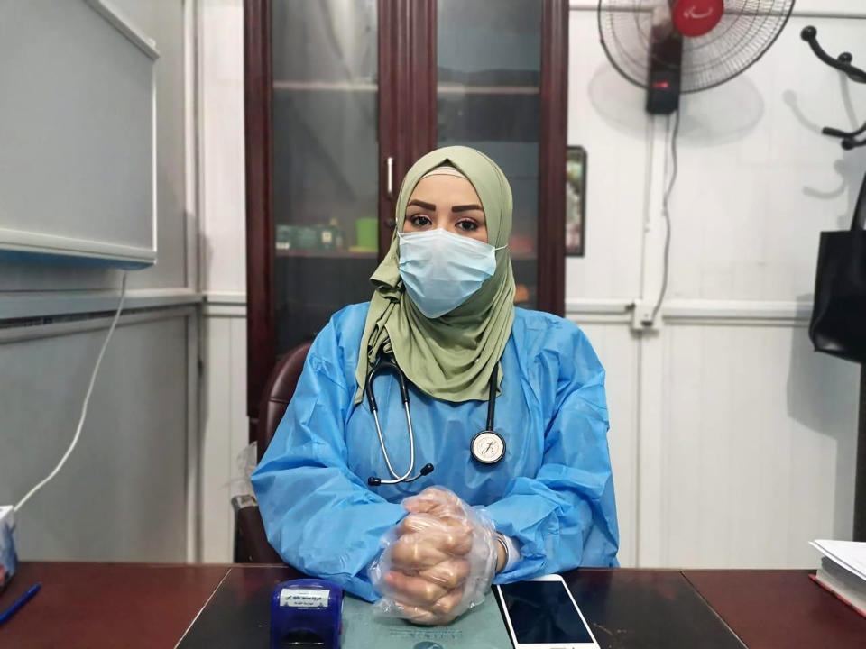 This May 13, 2020, picture provided by Dr. Marwa al-Khafaji shows the doctor back at work after 20 days in isolation after she tested positive for the coronavirus at a hospital in Karbala, Iraq. Dr. Marwa al-Khafaji’s homecoming from a hospital isolation ward was tainted by spite. Someone had barricaded her family home’s gate with a concrete block. The message from the neighbors was clear: She had survived coronavirus, but the stigma of having had the disease would be a more pernicious fight. (AP Photo)