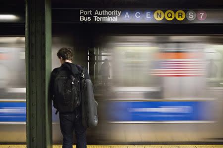 FILE PHOTO: A man waits for the subway at the Times Square stop in New York, December 19, 2012. REUTERS/Andrew Burton