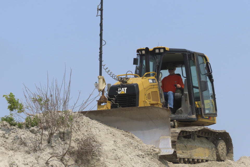 A bulldozer reshapes a sand dune on the North Wildwood, N.J. beach on May 22, 2023. A recent winter storm in January 2024 punched a hole through what is left of the city's eroded dune system, leaving it more vulnerable than ever to destructive flooding as the city and state fight in court over how best to protect the popular beach resort. (AP Photo/Wayne Parry)